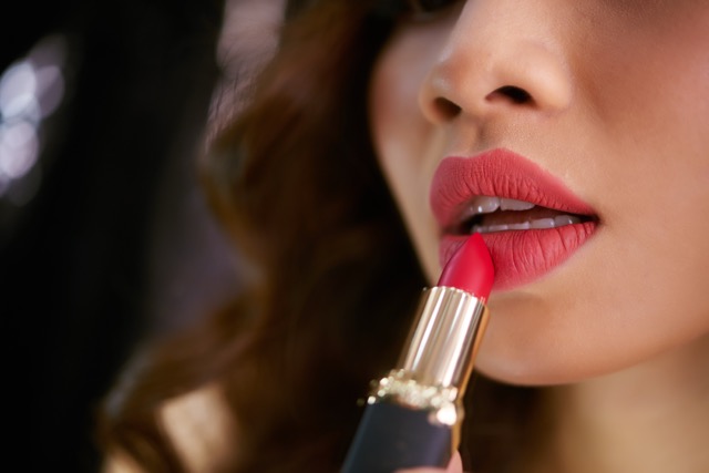 Closeup lipstick touching plump red female lips — Rika Beauty & Spa, Uluwatu