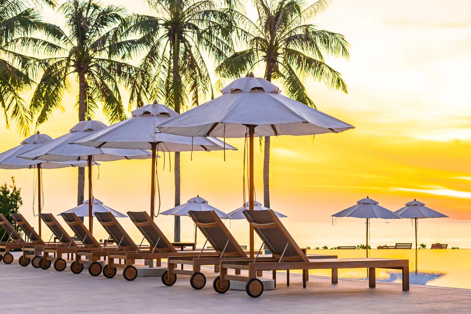 Poolside daybeds at sunset, ready for a beach club evening in Bali